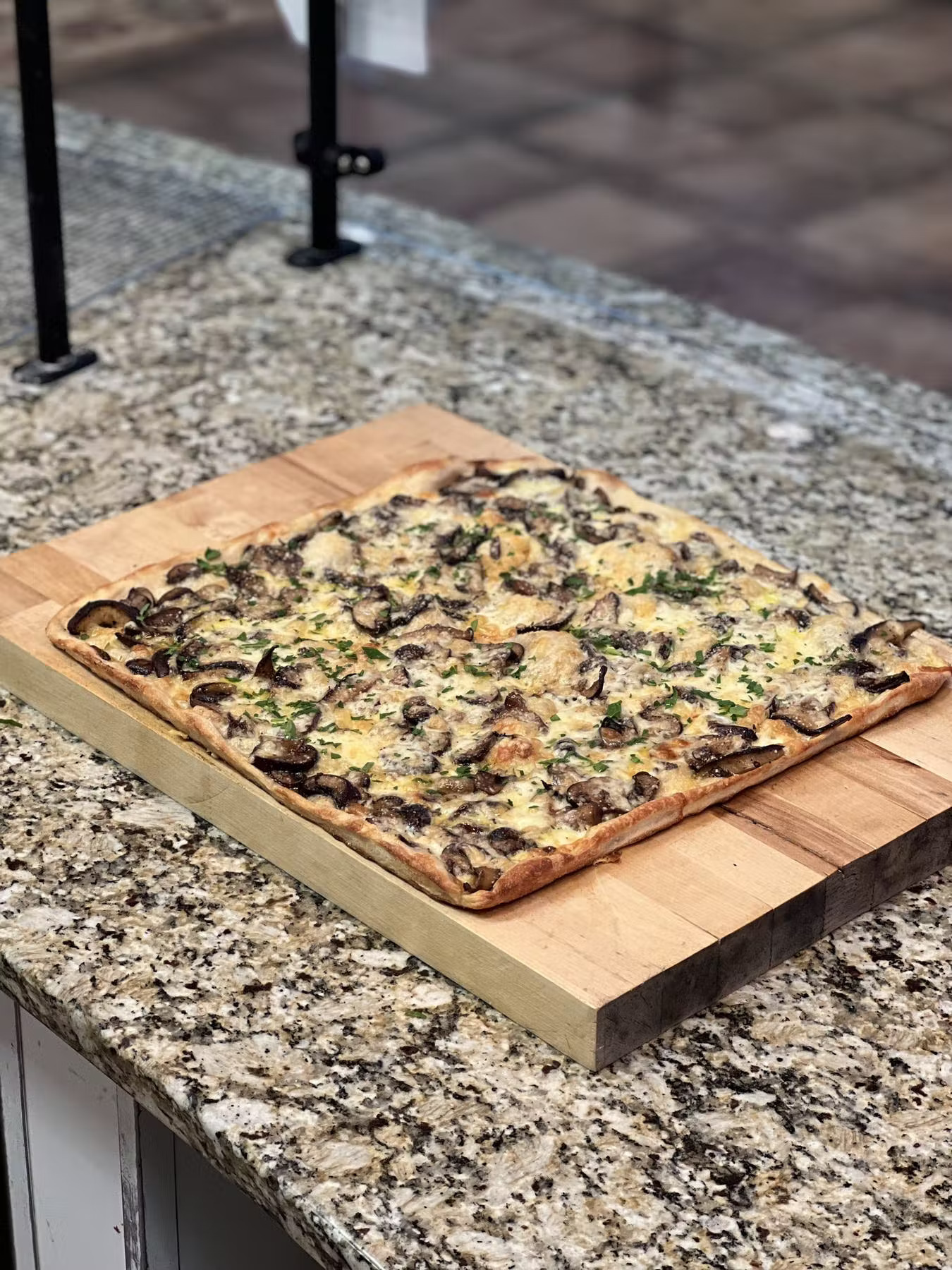 a pizza sitting on top of a wooden bench