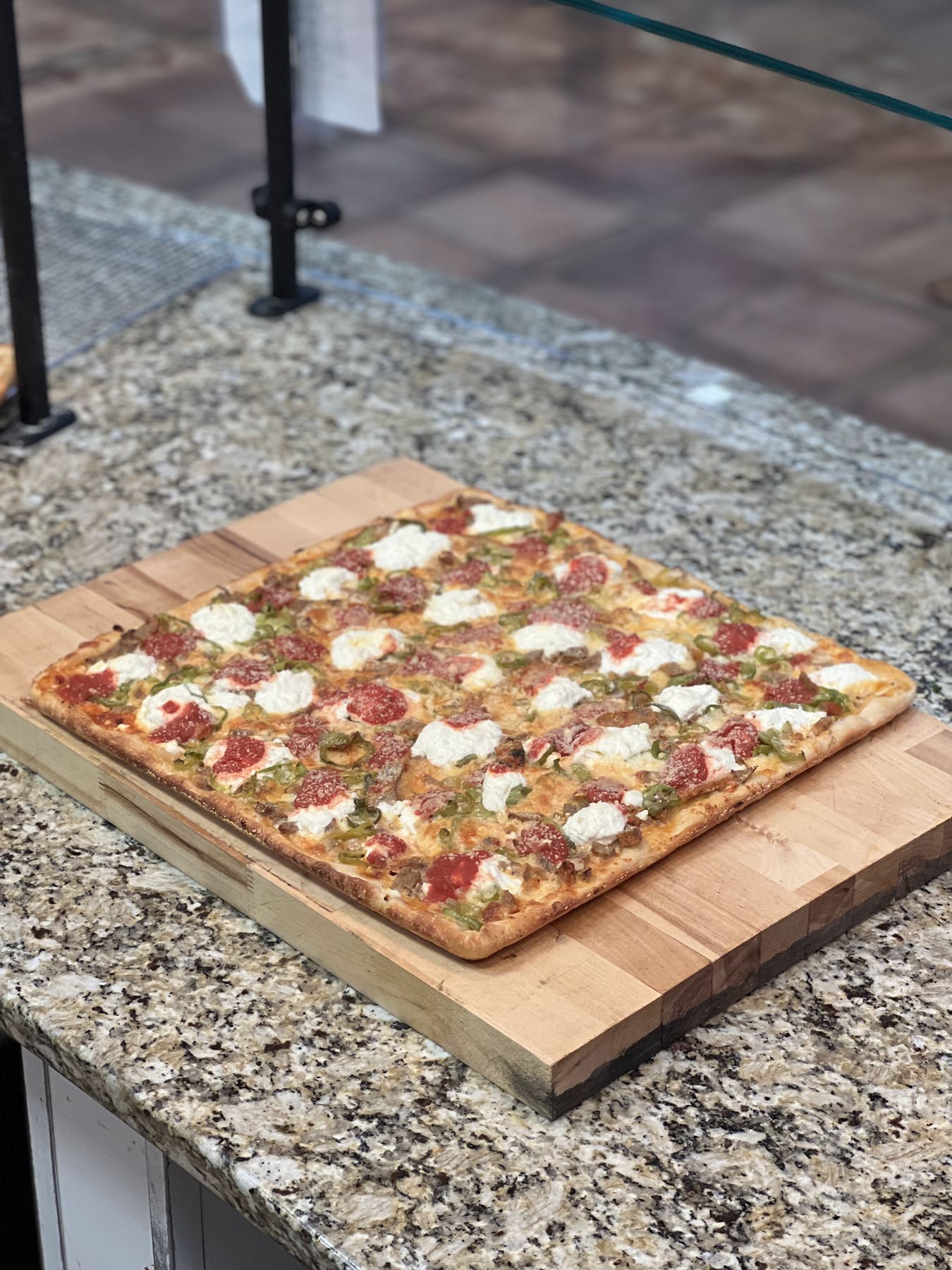 a pizza sitting on top of a wooden cutting board