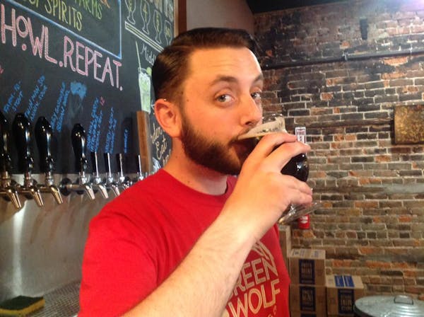 a man drinking a glass of beer