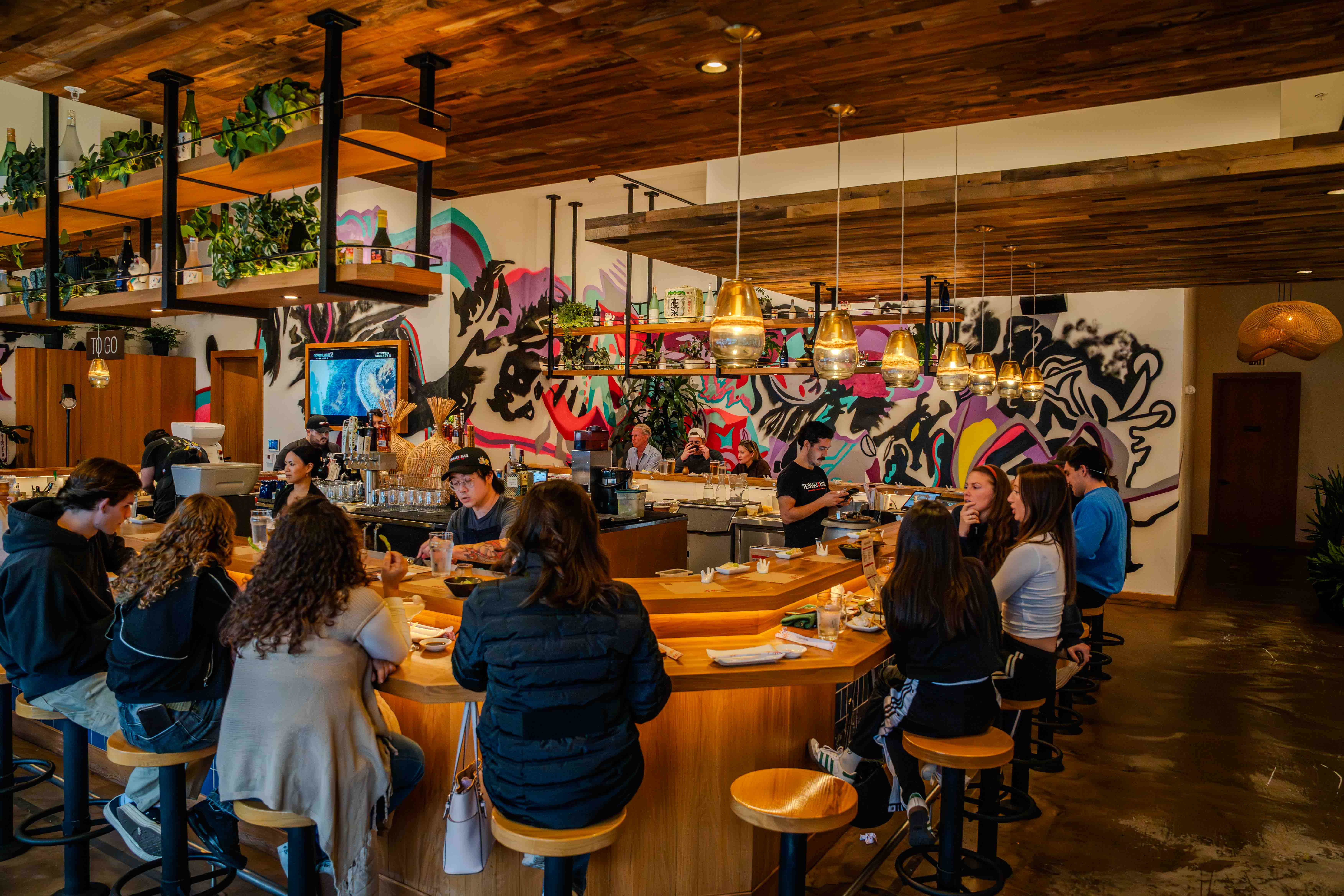 Couple enjoying hand roll sushi at Temaki Bar Sushi in Encinitas with surf-inspired interiors.