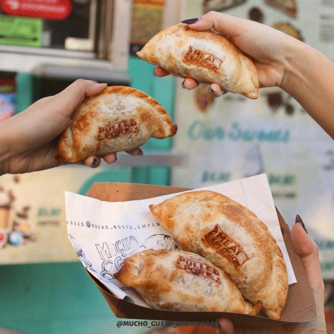 a hand holding a slice of pizza