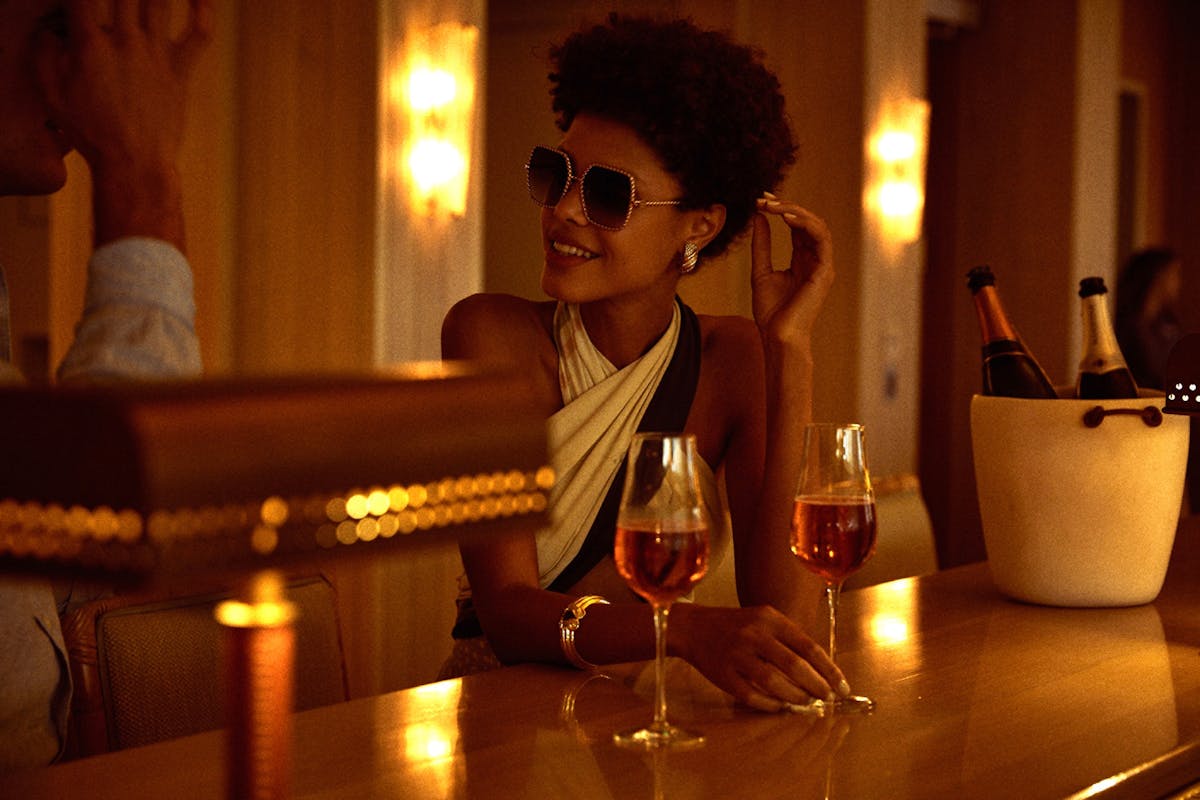 a woman sitting at a bar with a glass of wine during happy hour at Florie's in Palm Beach