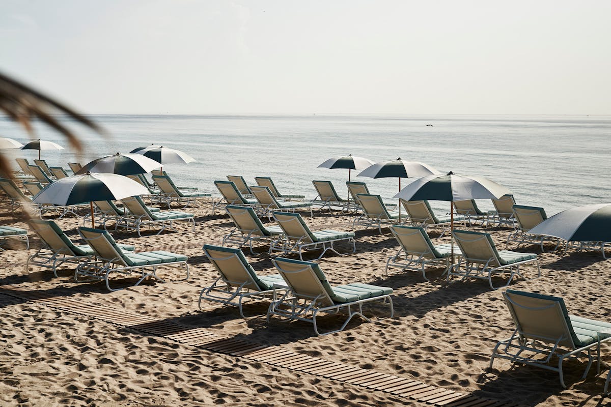 a group of lawn chairs sitting on top of a beach