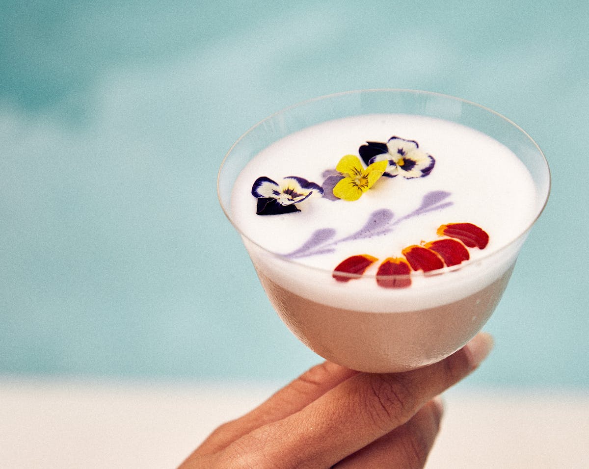 a botanical craft cocktail topped with floating flower petals at Florie's Bar in Palm Beach