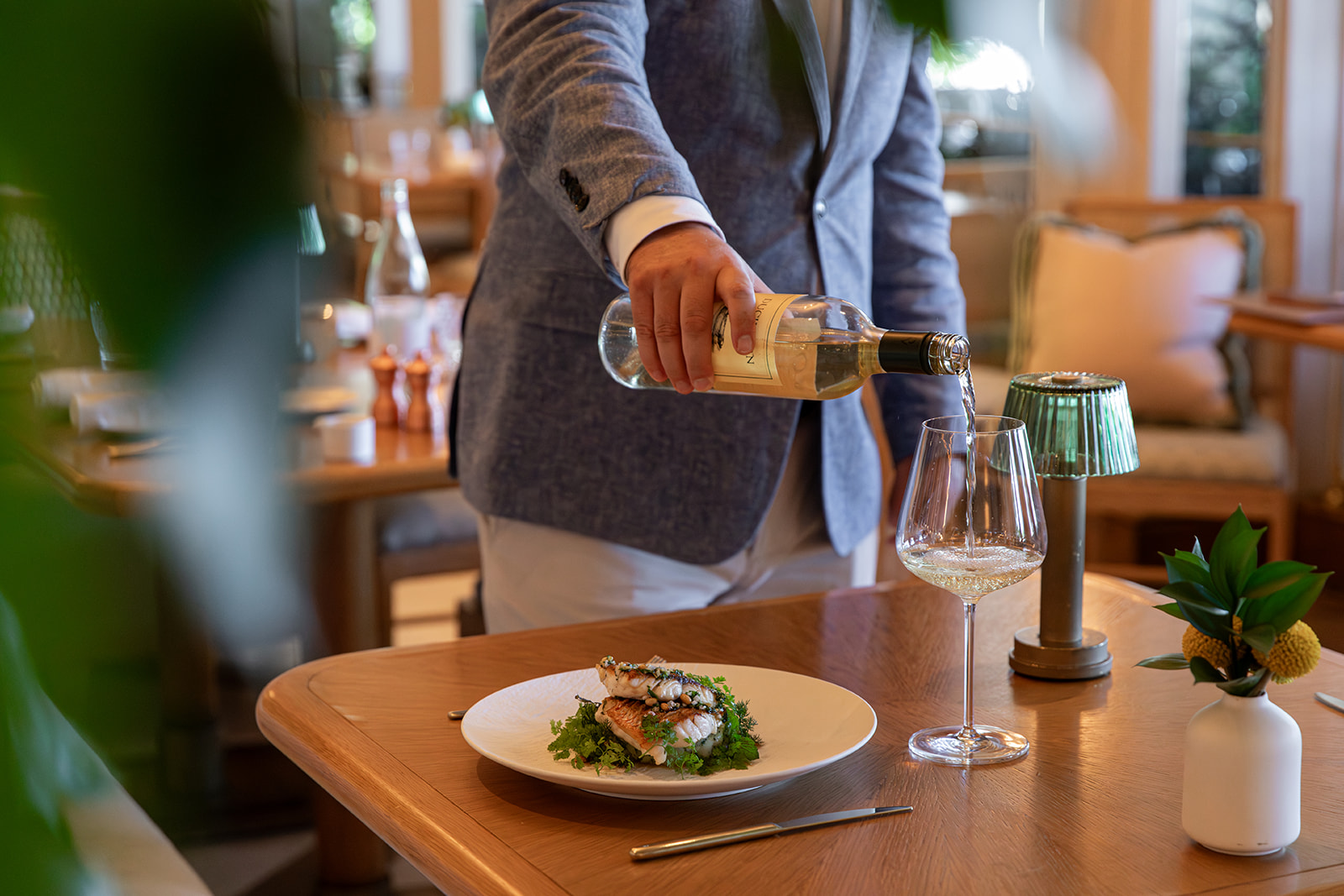 a person pouring wine into a plate of food