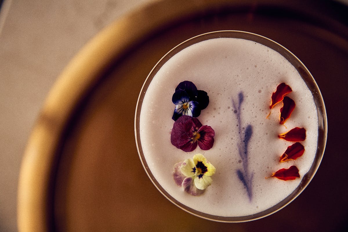 the top of a cocktail garnished with fresh tropical flower petals at Florie's Bar in Palm Beach