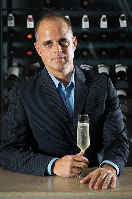 Sommelier Joe Pena holding a glass of Champagne