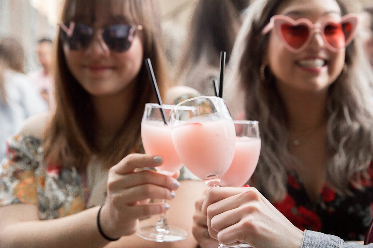 a woman wearing glasses holding a glass of wine