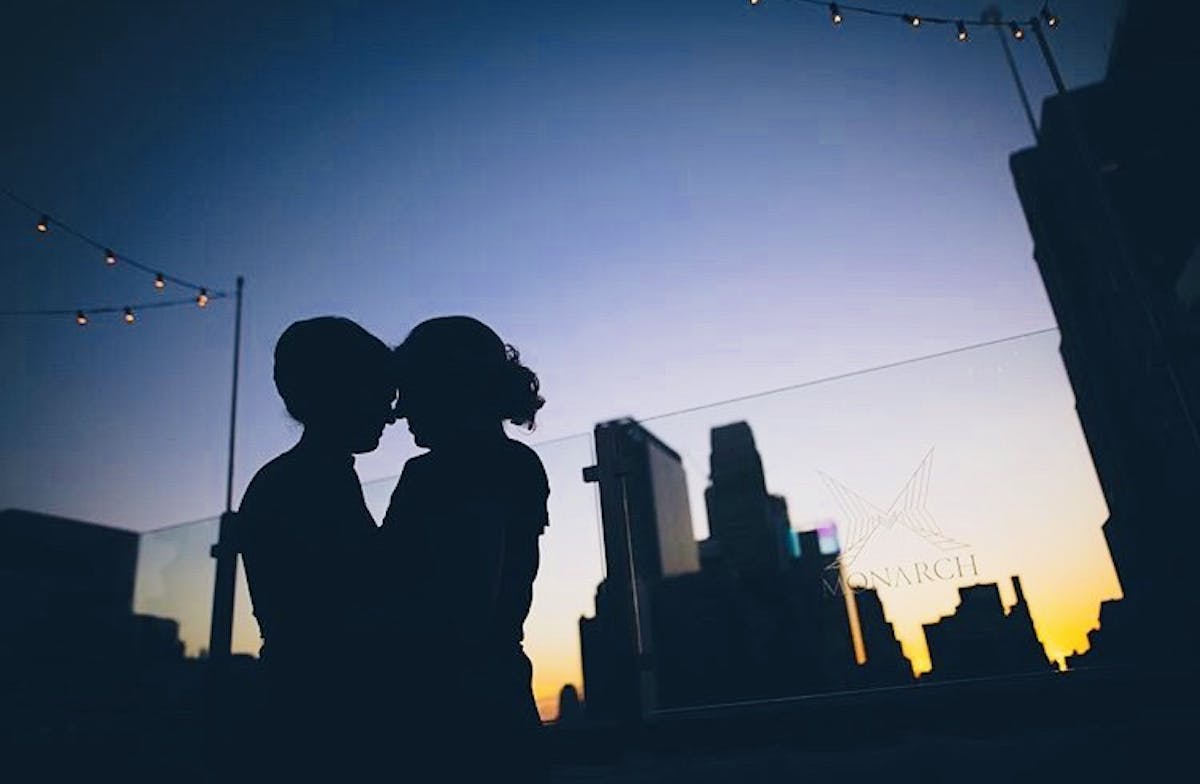 two people standing together with the sunset