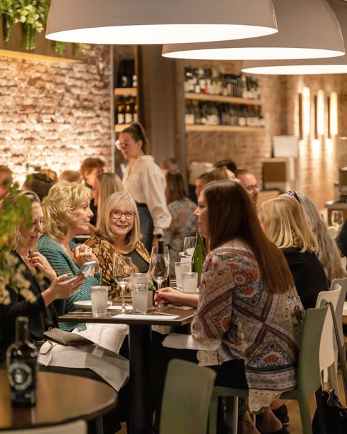 a group of people sitting at a table in a restaurant