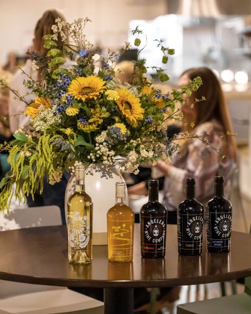 a bottle of wine and a vase of flowers on a table
