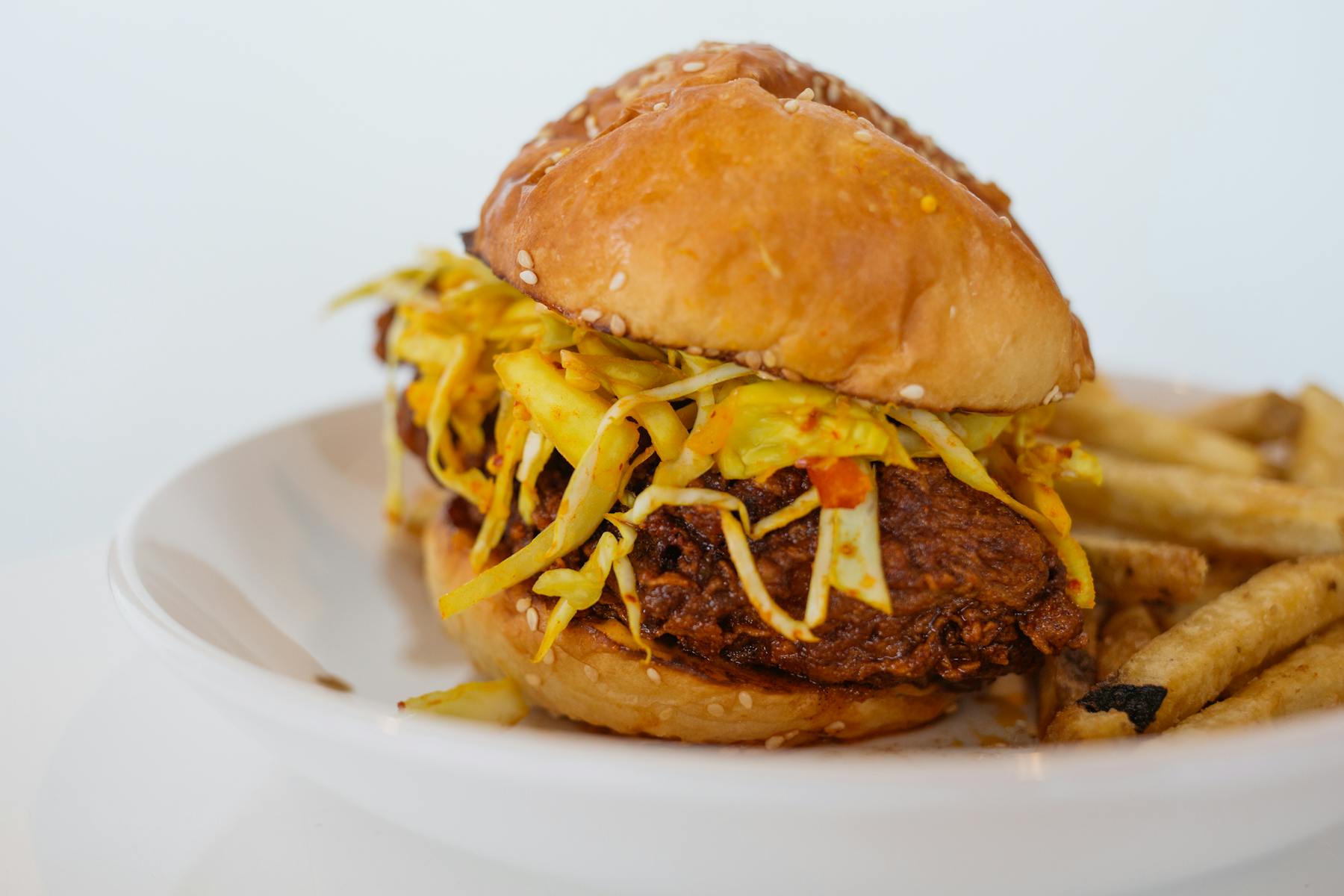 a close up of a big cheese burger sitting on a plate