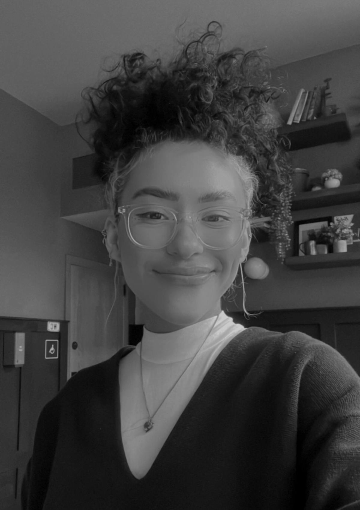 a person wearing glasses and smiling at the camera