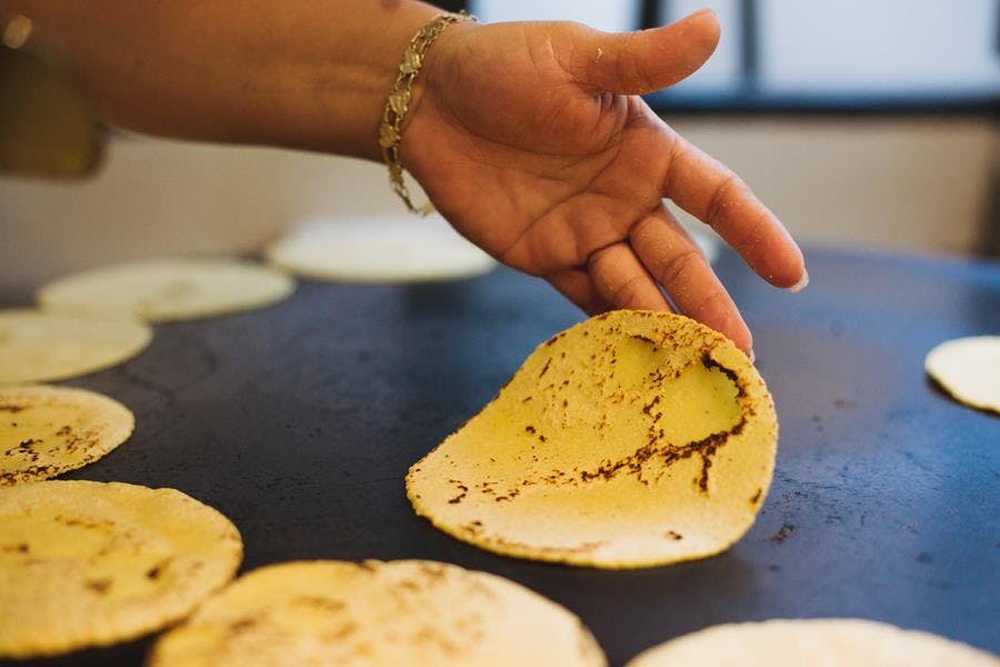 a close up of a person cutting a piece of bread