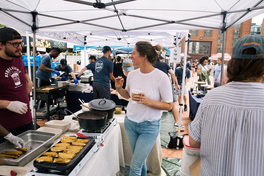 a group of people standing around a table with food