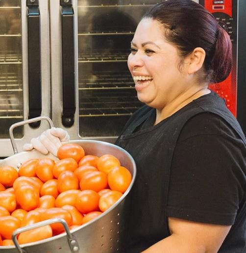 a person standing in front of a fruit stand