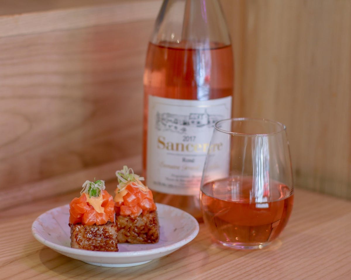 a plate of food and a bottle of wine on a table