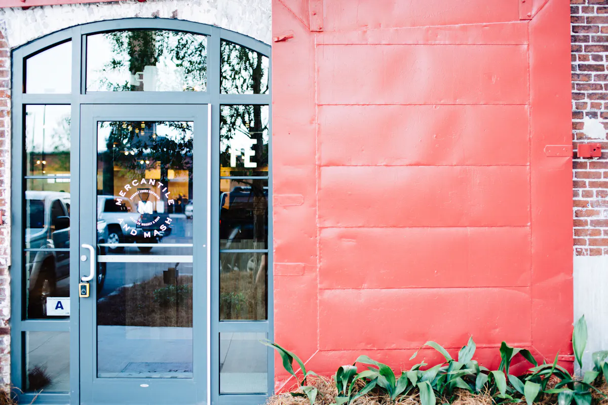 a large brick building with a red door
