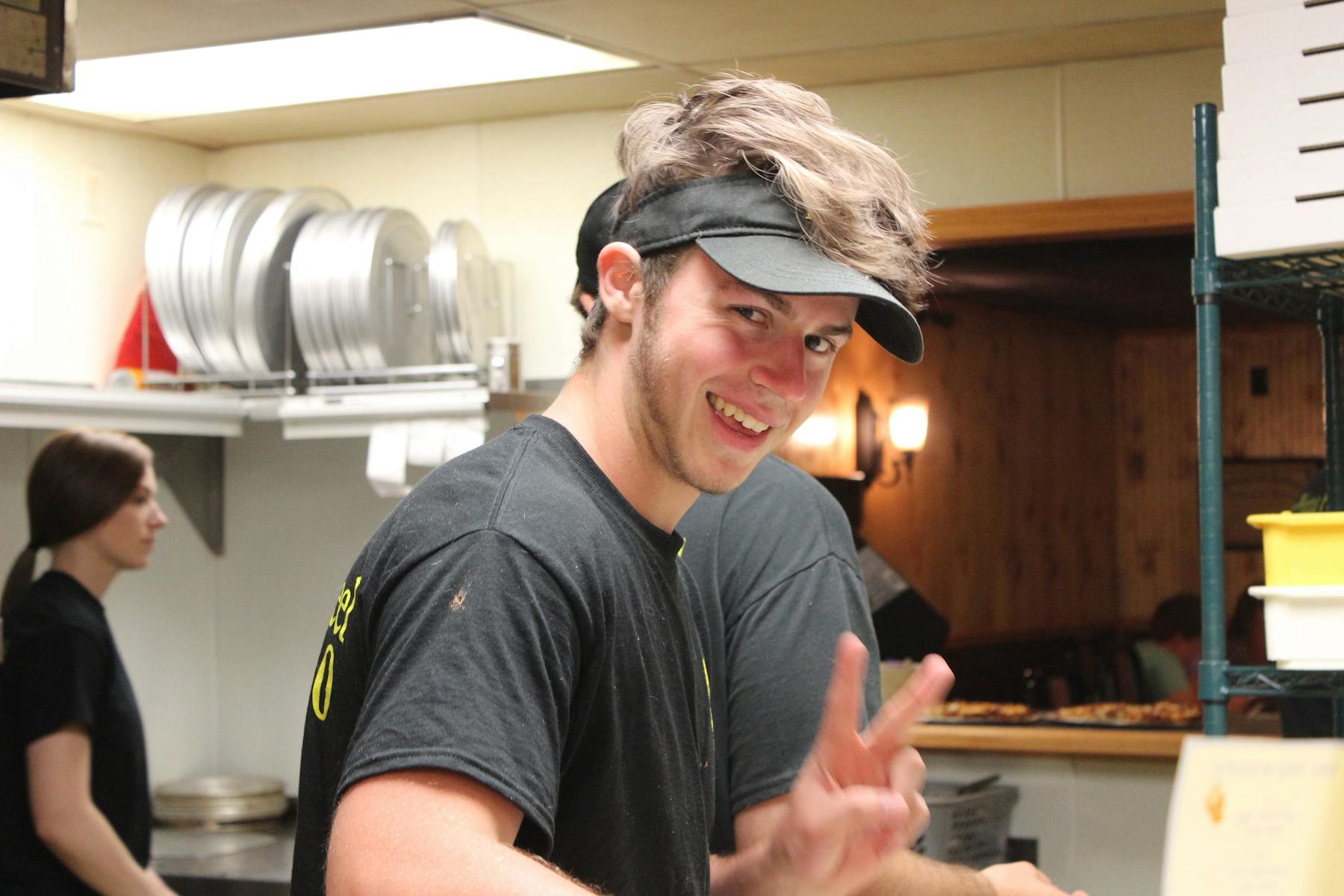 a man preparing food in a kitchen and a man posing for the camera