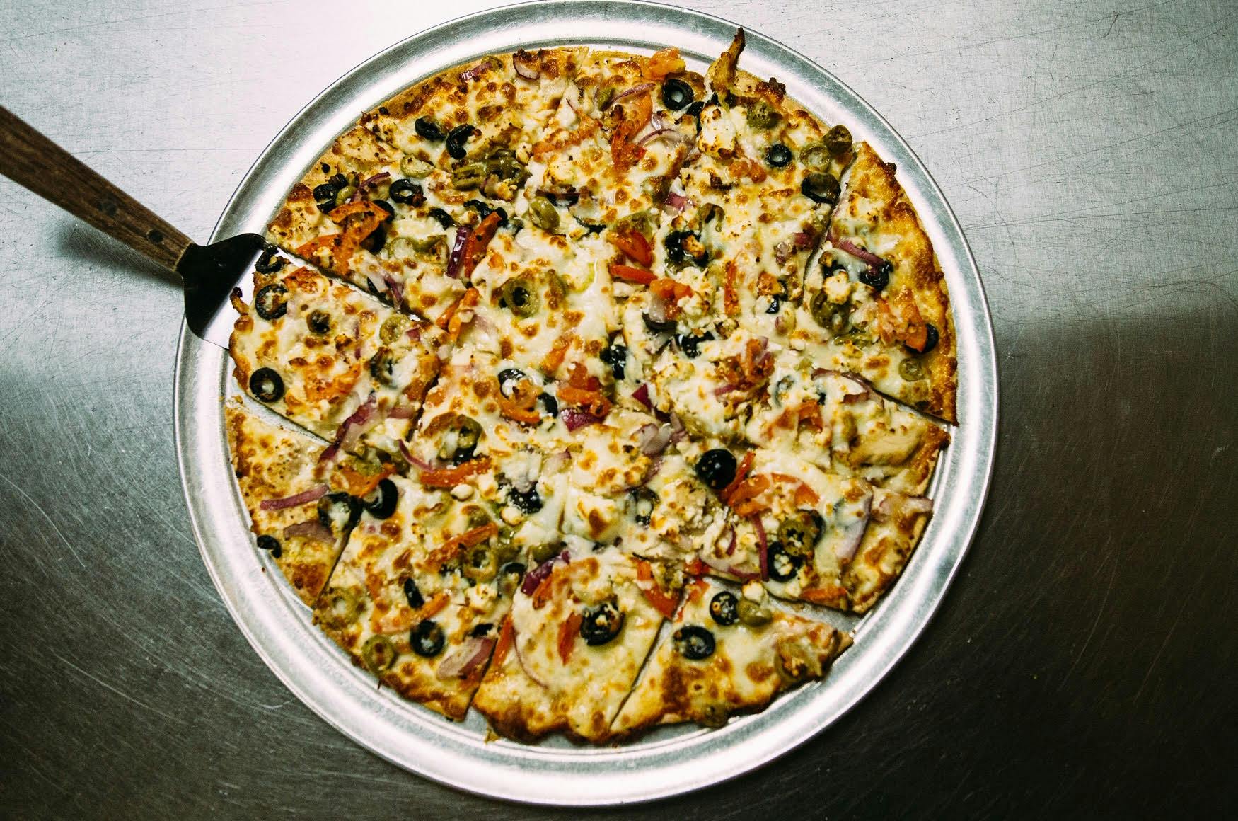 a pizza sitting on top of a pizza tray on a table