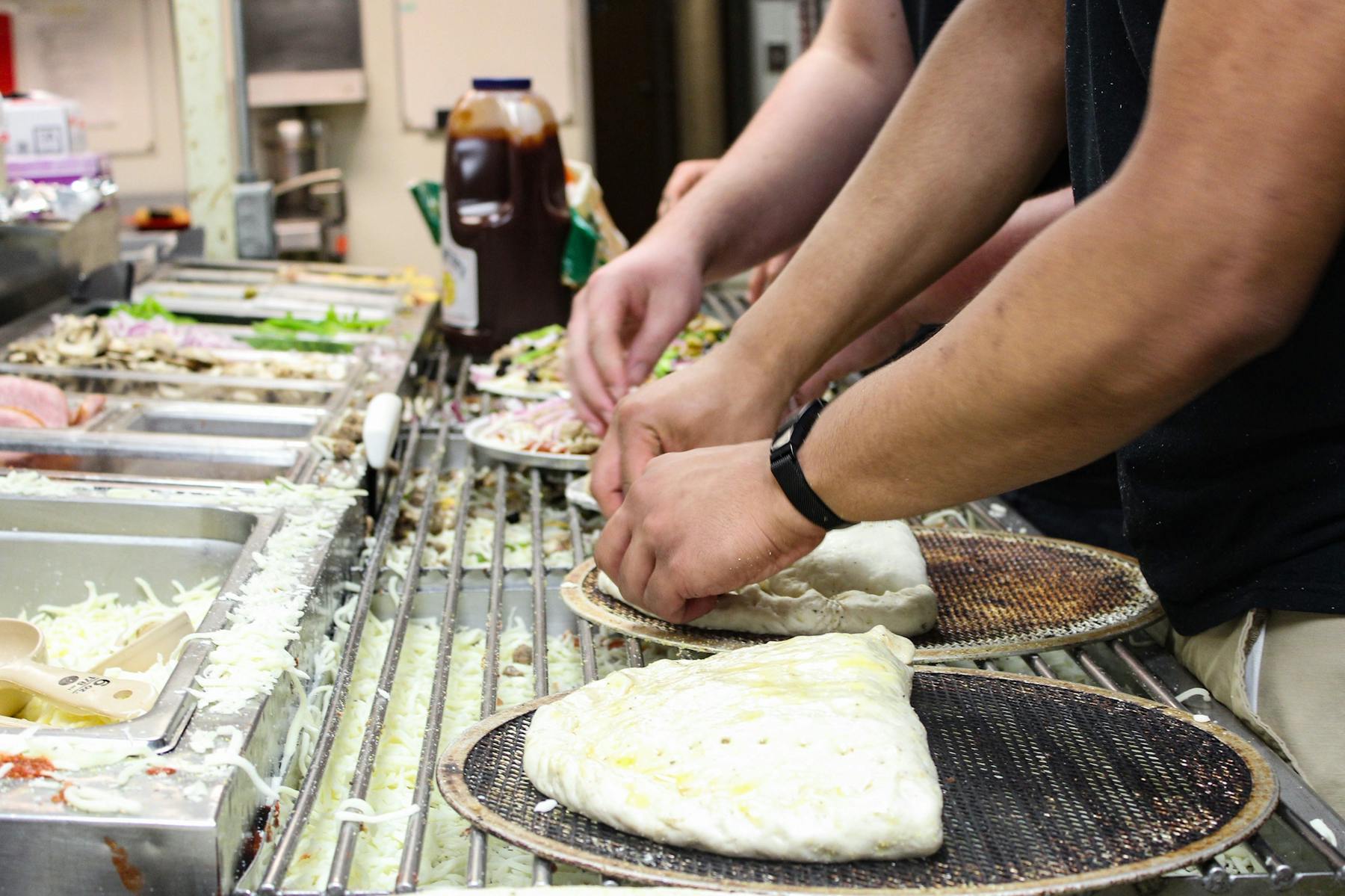 persons hand crafting a dough