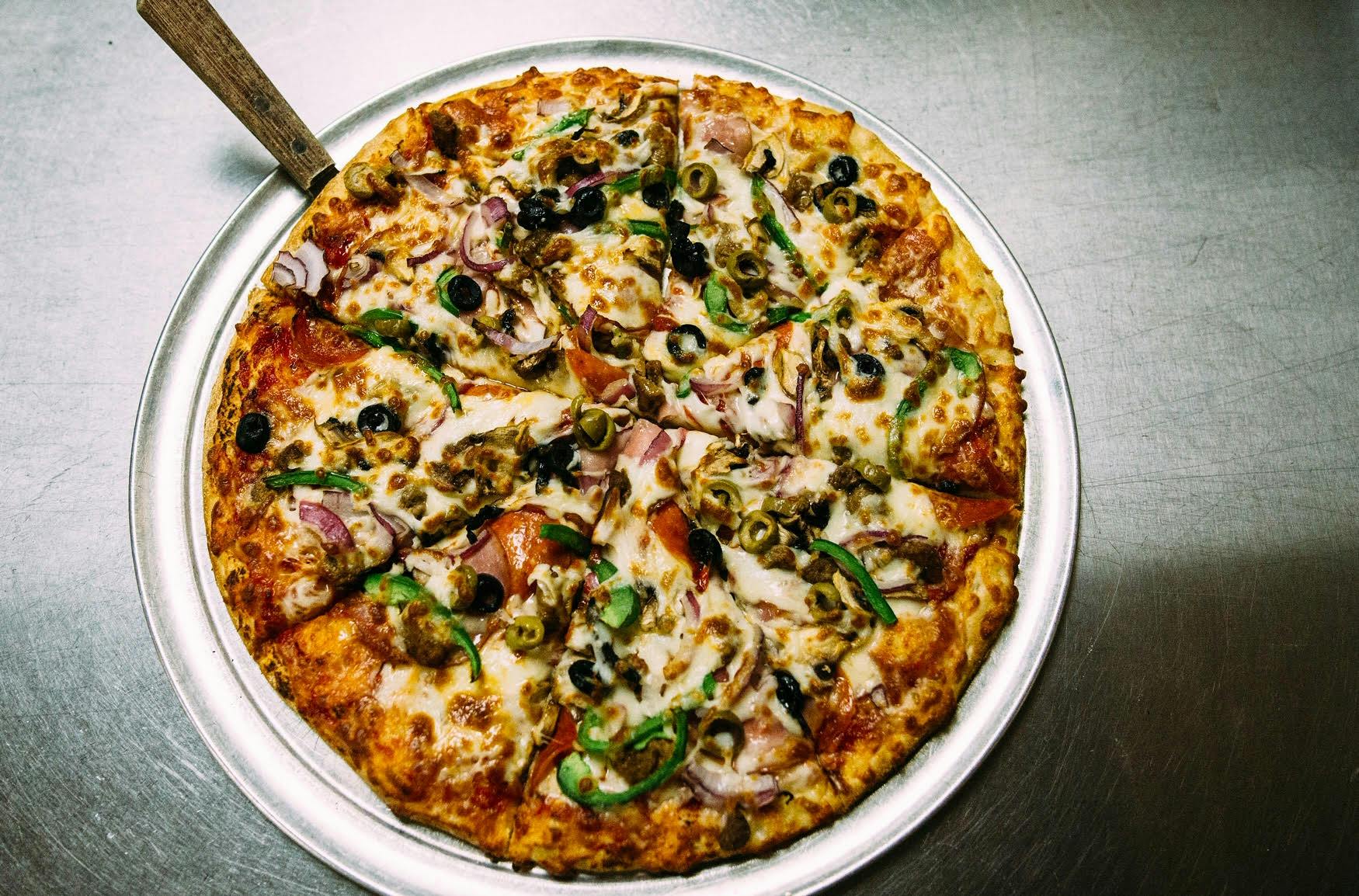 a pizza sitting on top of a pizza tray on a table