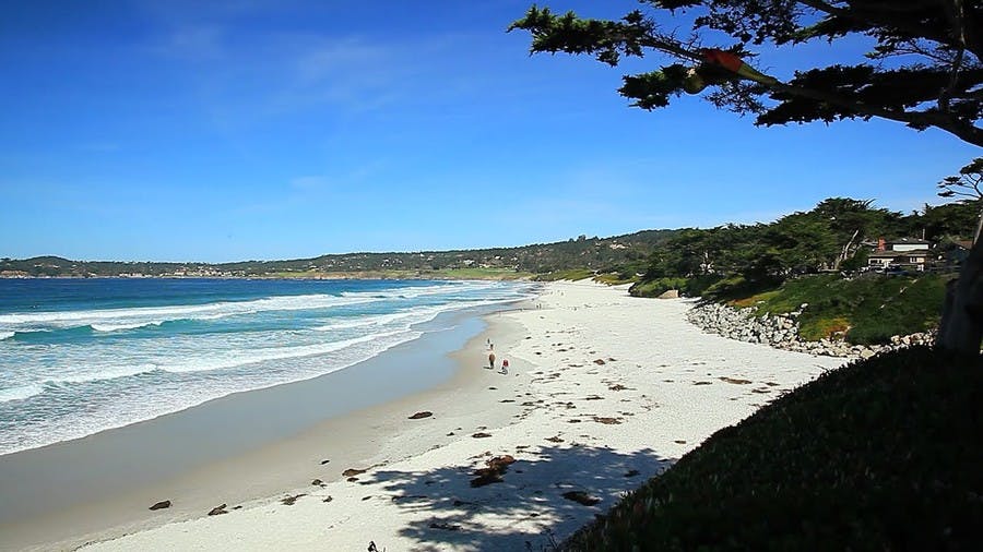 a sandy beach next to a body of water