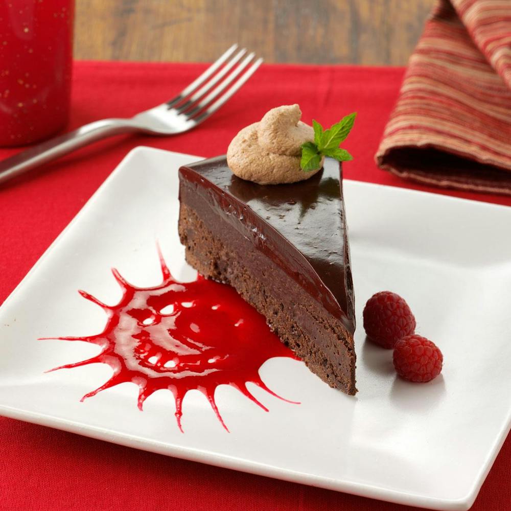 a piece of cake sitting on top of a red plate on a table