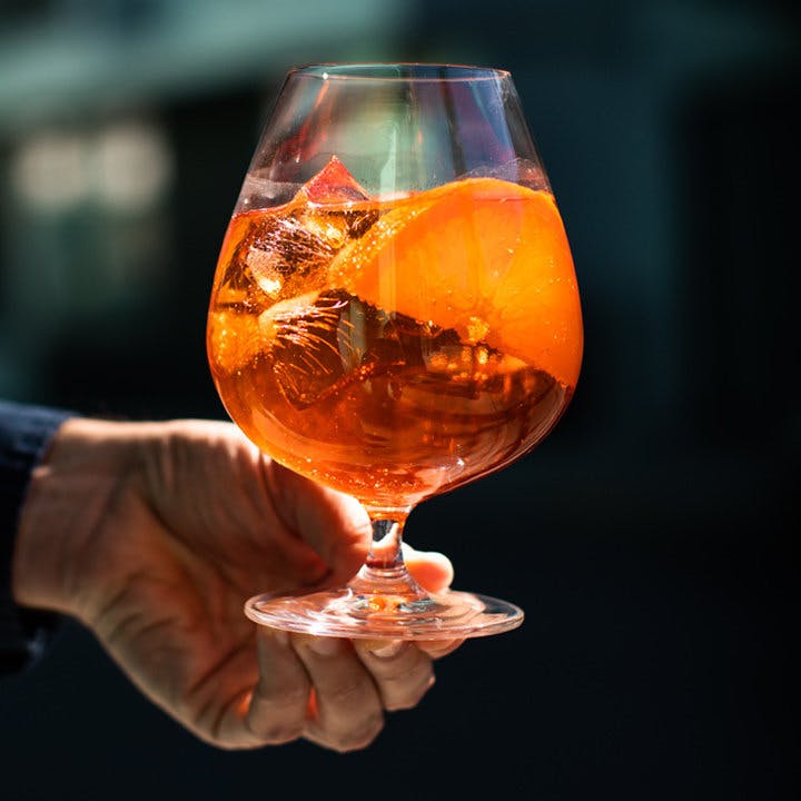 a hand holding a glass of orange juice