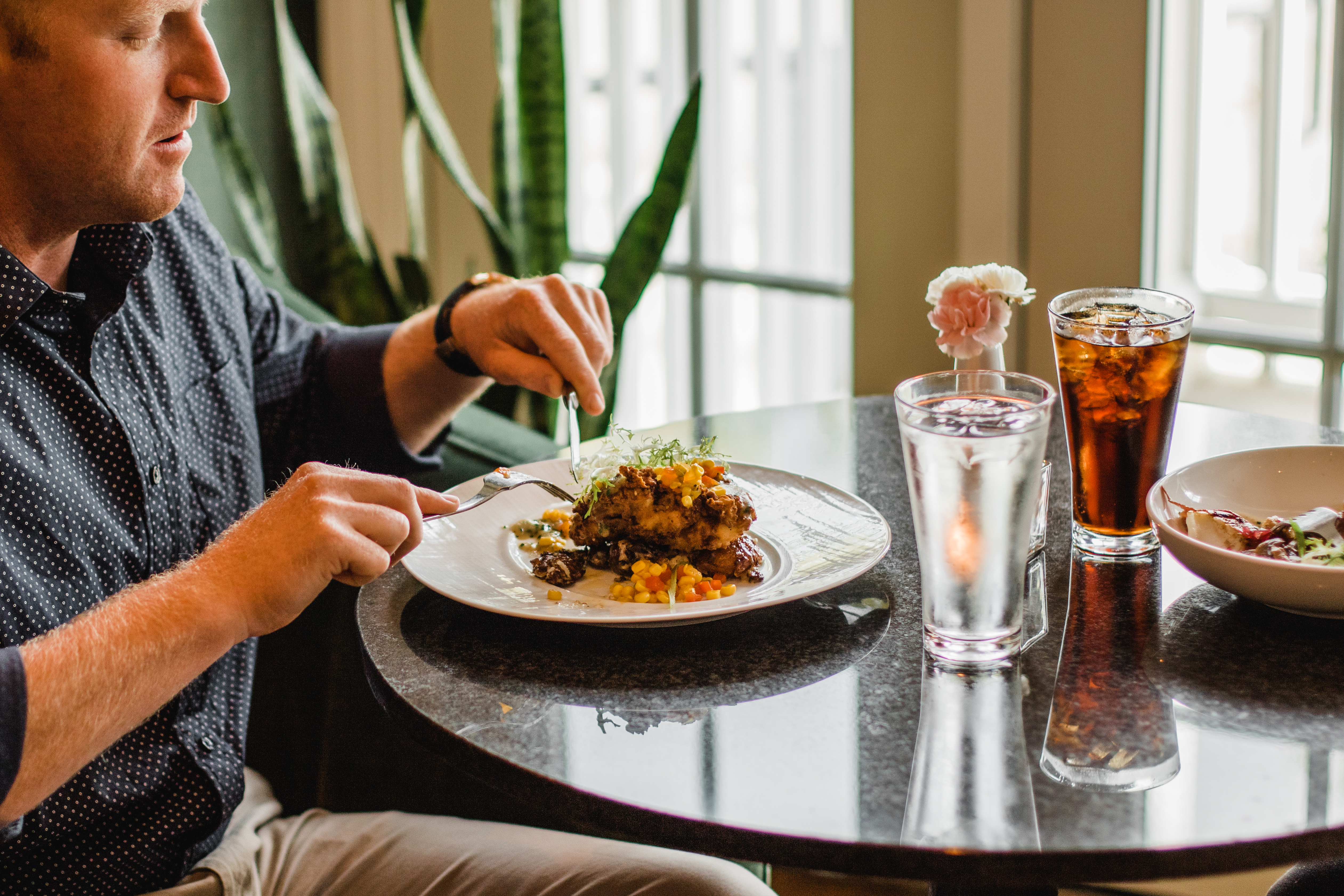 a man sitting at a table with a plate of food