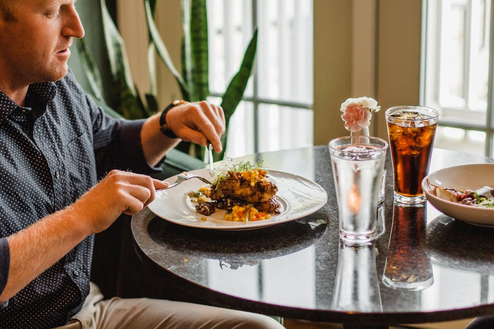 a man sitting at a table with a plate of food