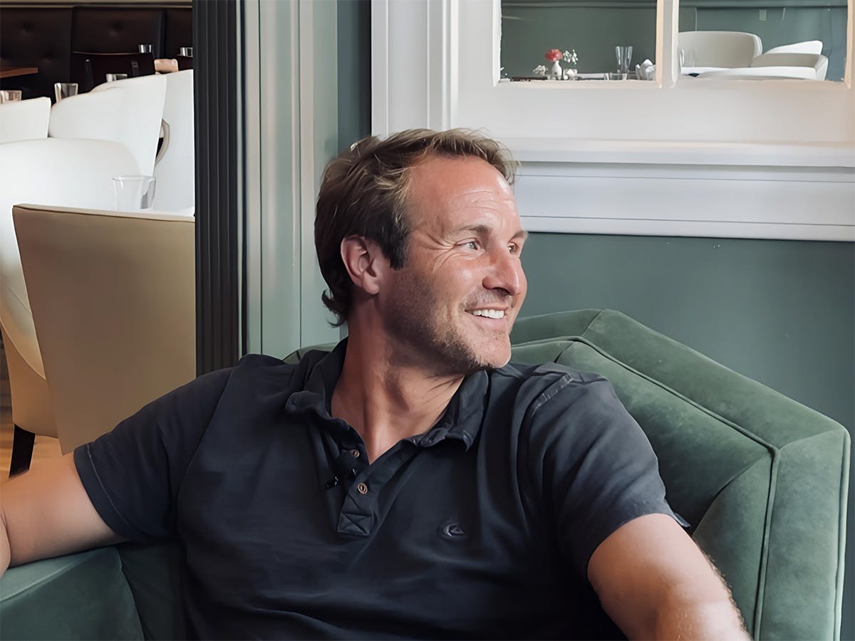 Jason Clarke sitting in front of a window