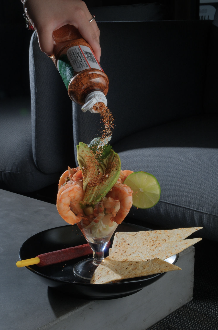 Tajin being sprinkled onto shrimp cocktail