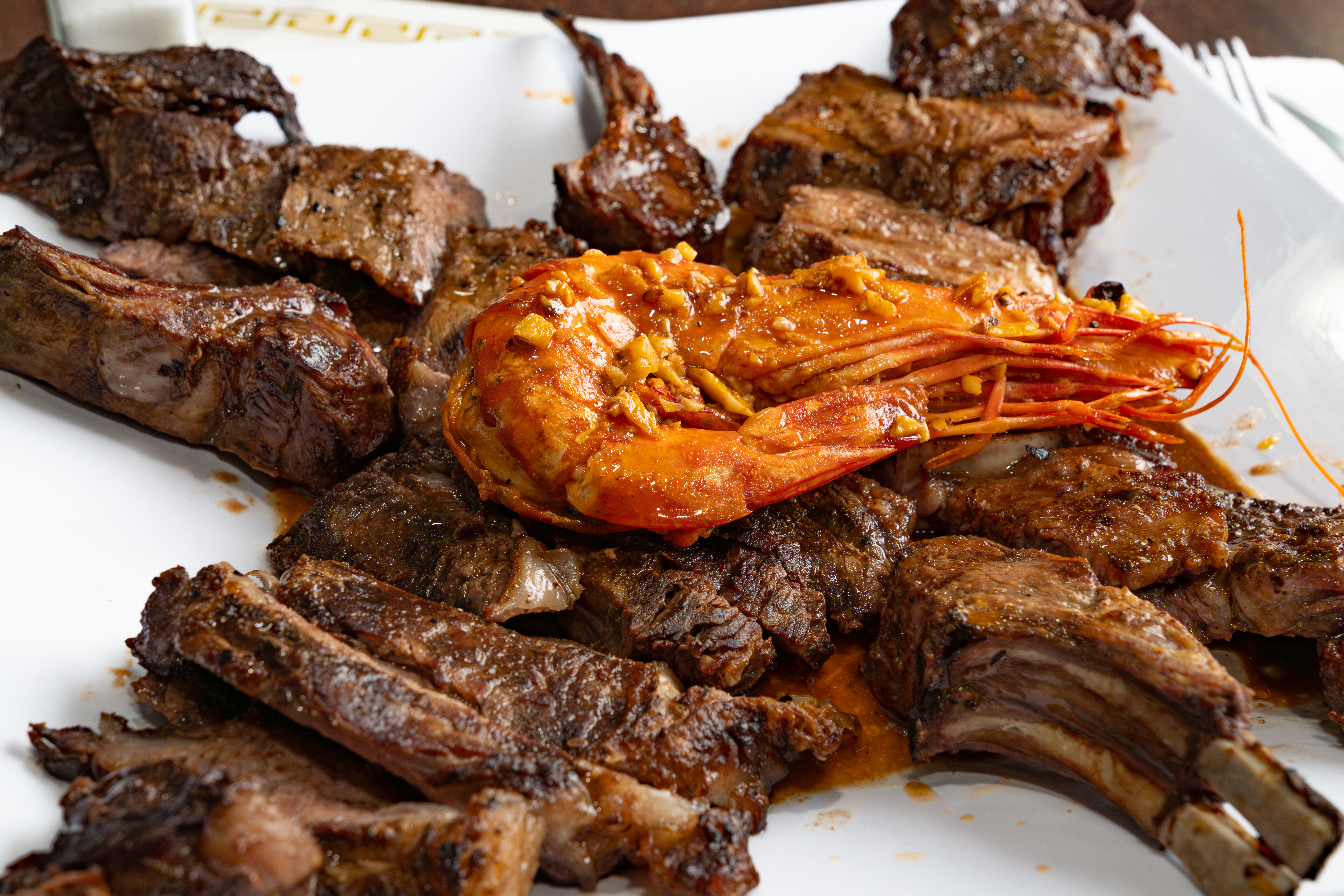 a plate of meat with a shrimp