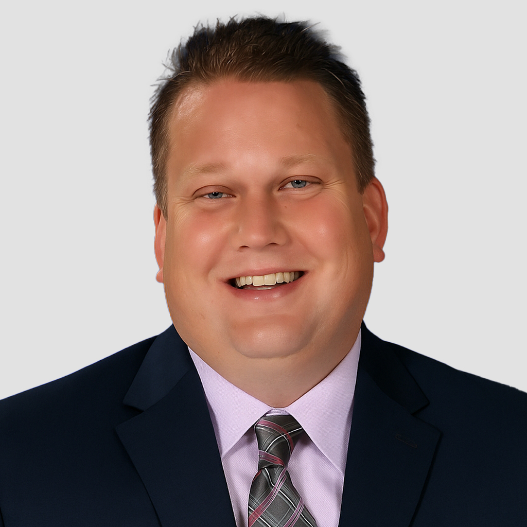 a man wearing a suit and tie smiling at the camera