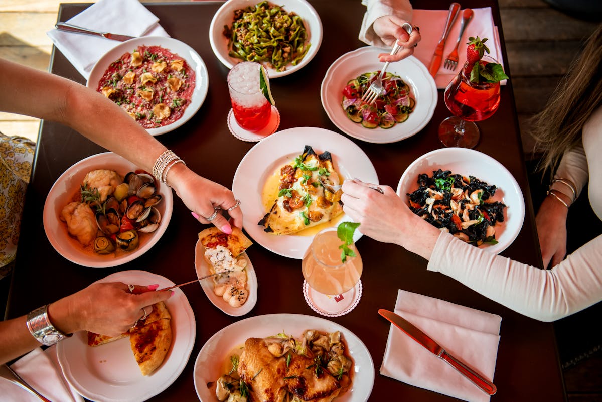 a group of people sitting at a table with a plate of food