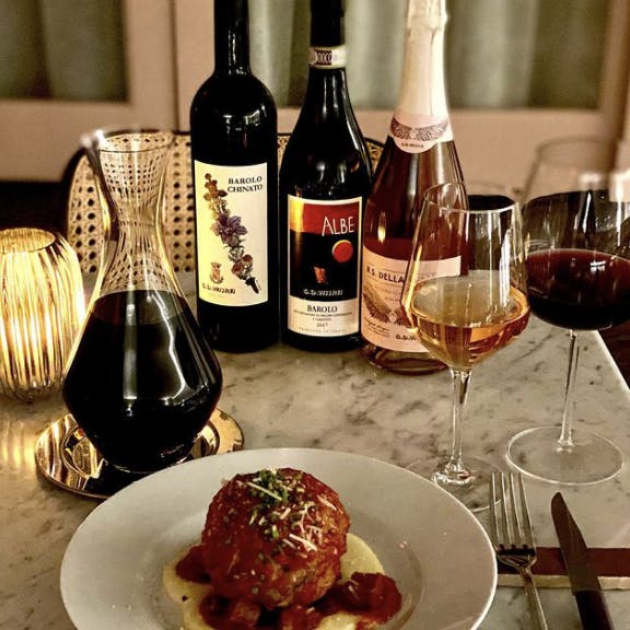 a plate of food and a bottle of wine on a table