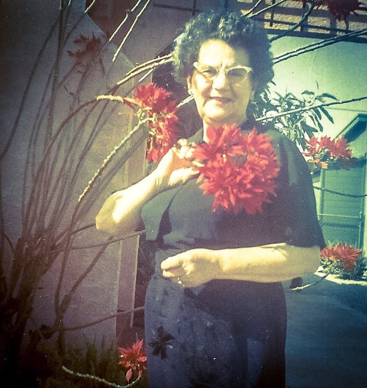 a person sitting at a table with a vase of flowers