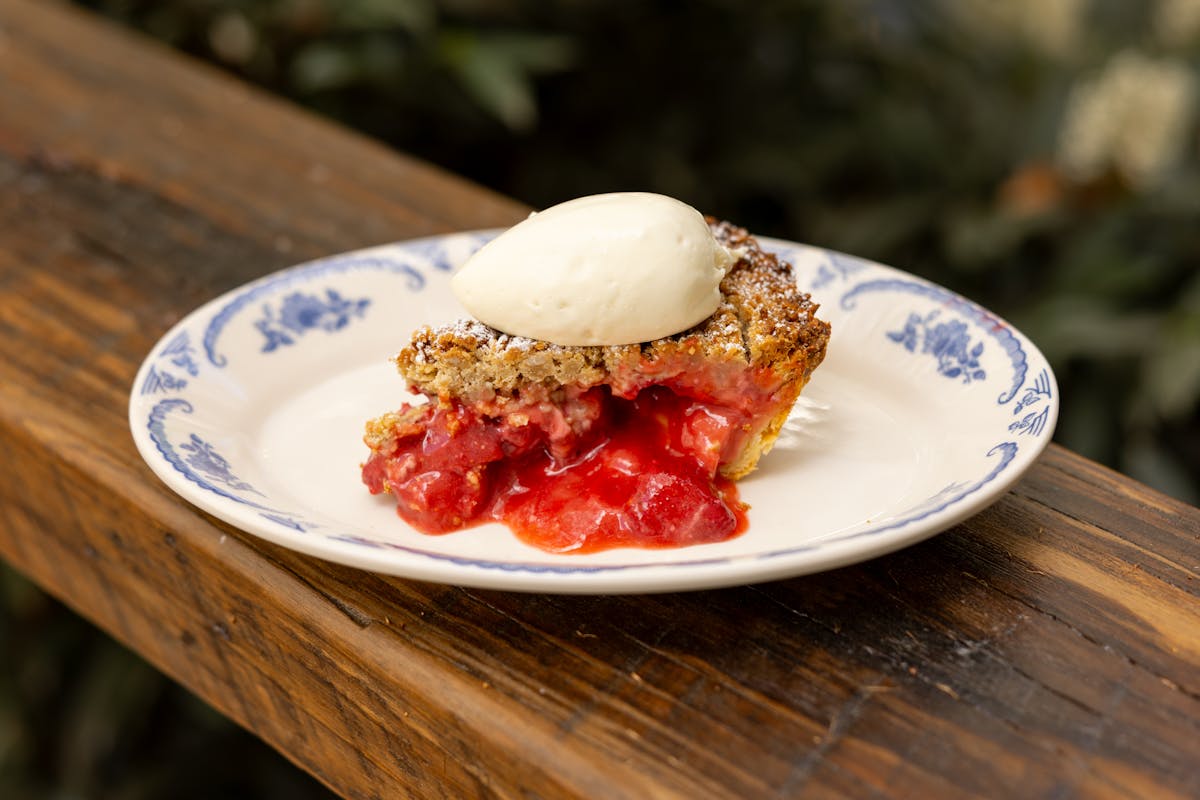a plate with a piece of cake sitting on top of a wooden table