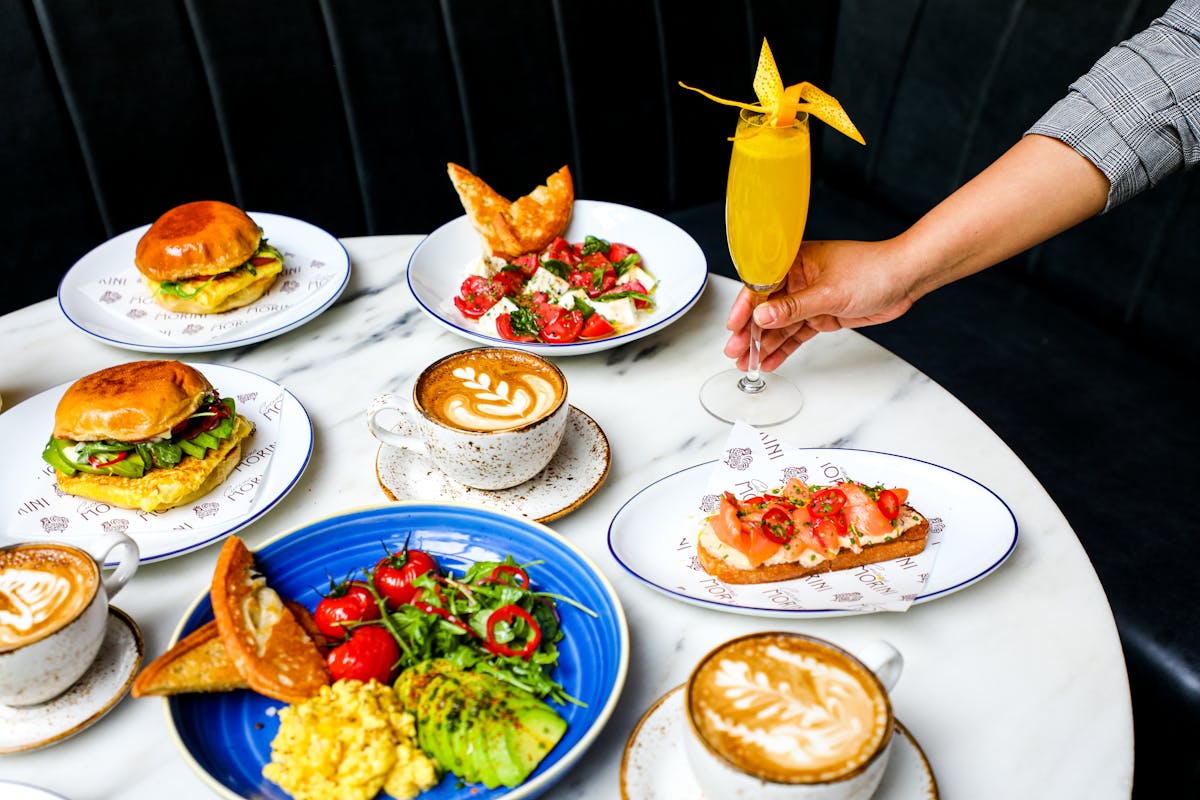a person sitting at a table with plates of food on a plate