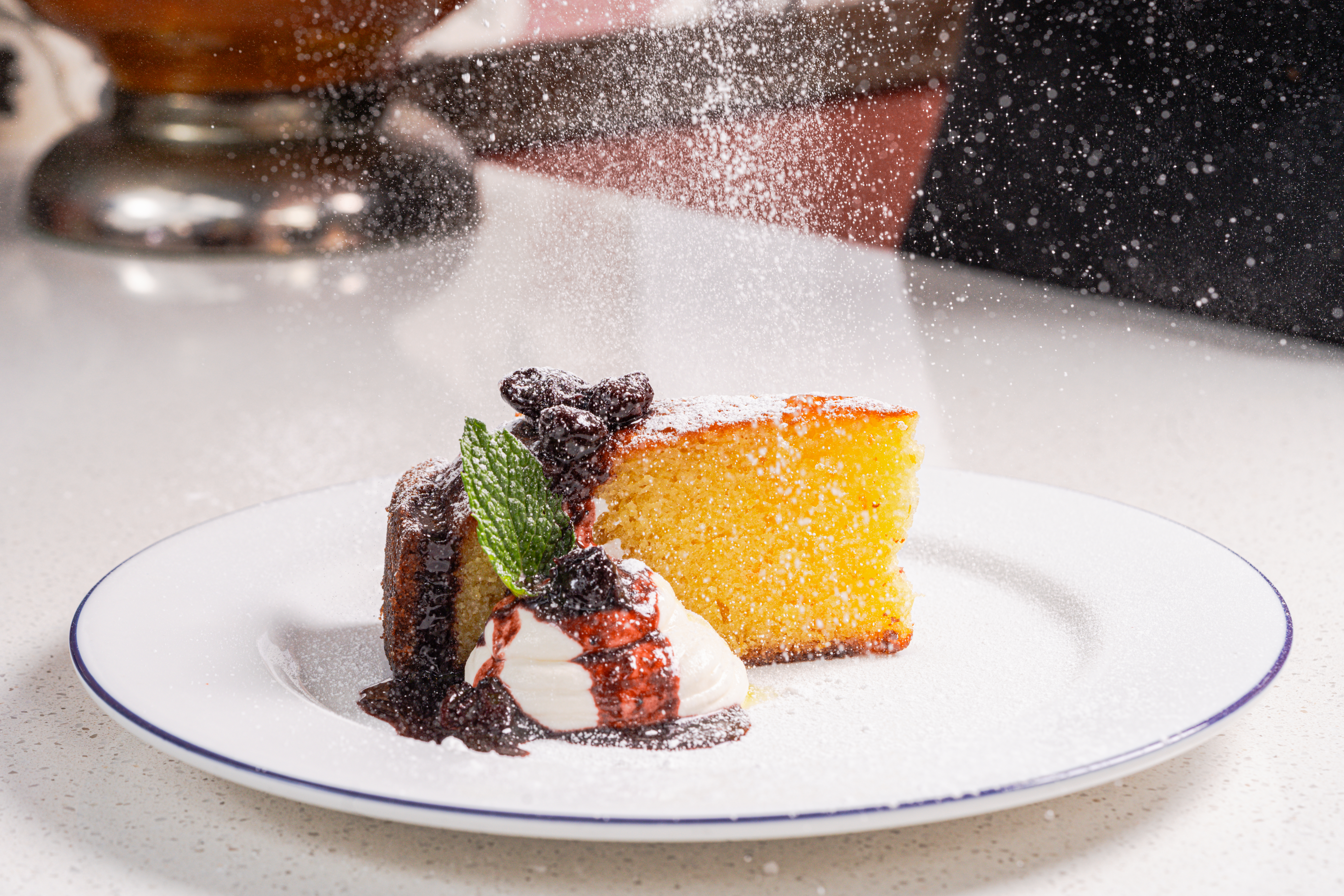 a slice of cake with ice cream and chocolate sauce on a white plate