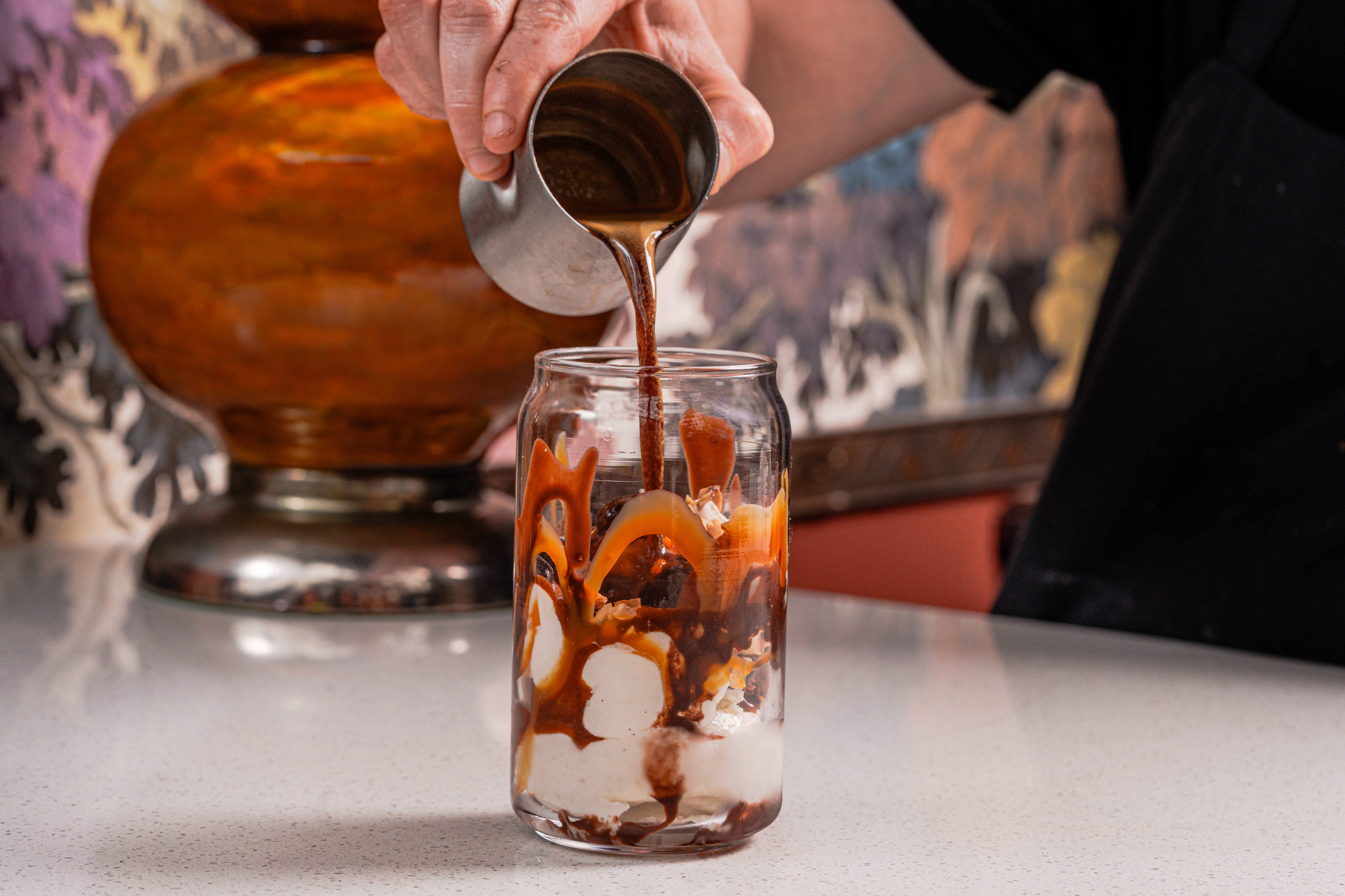 a person pouring liquid into a glass