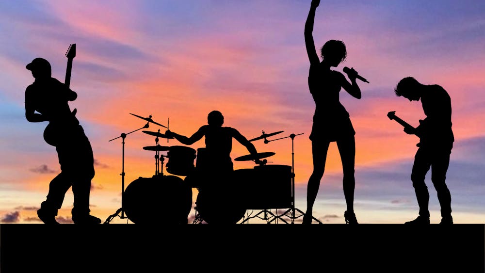 a group of people standing in front of a sunset