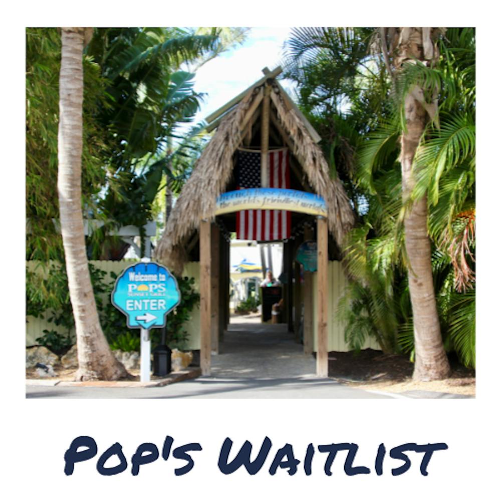 a sign in front of a palm tree