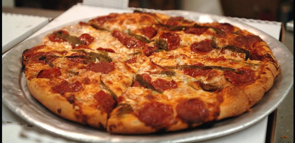 a pizza sitting on top of a white plate