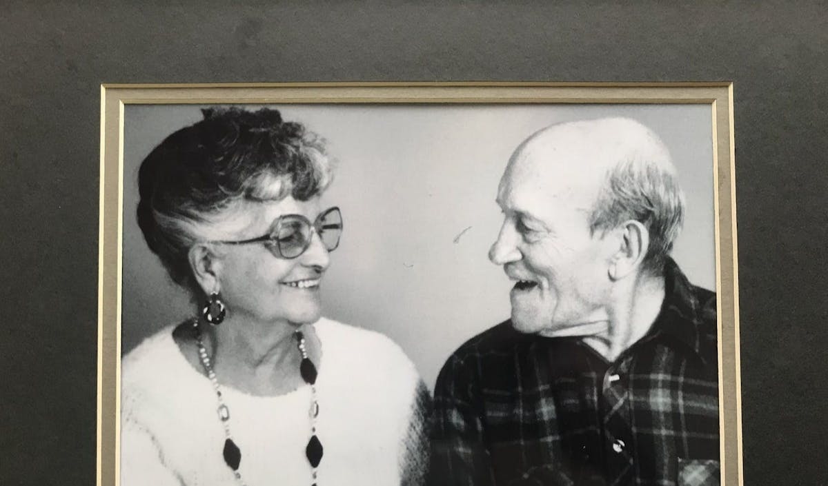 a man and woman standing in front of a mirror posing for the camera