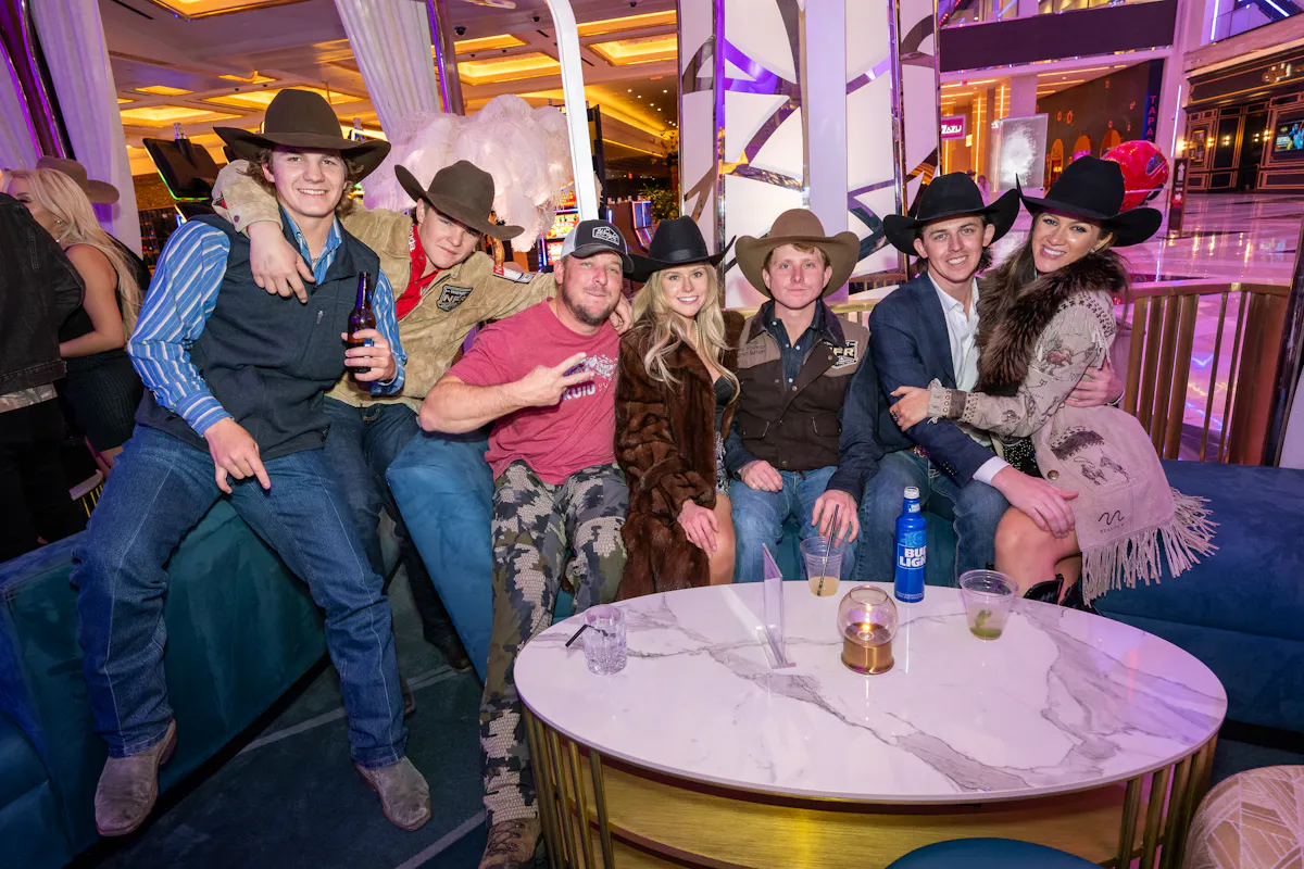 a group of people sitting at a table with a cake