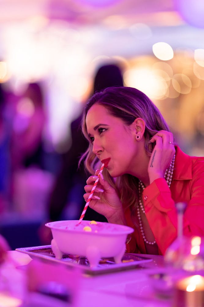 a close up of a woman drinking a cocktail