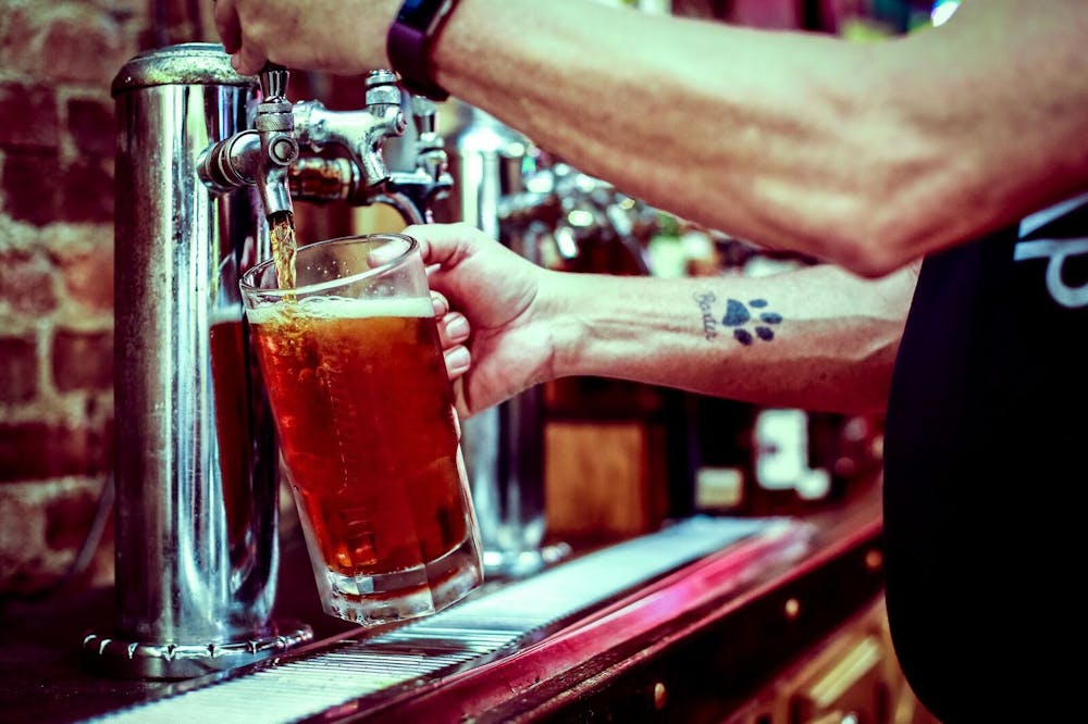 a man holding a glass of beer on a table