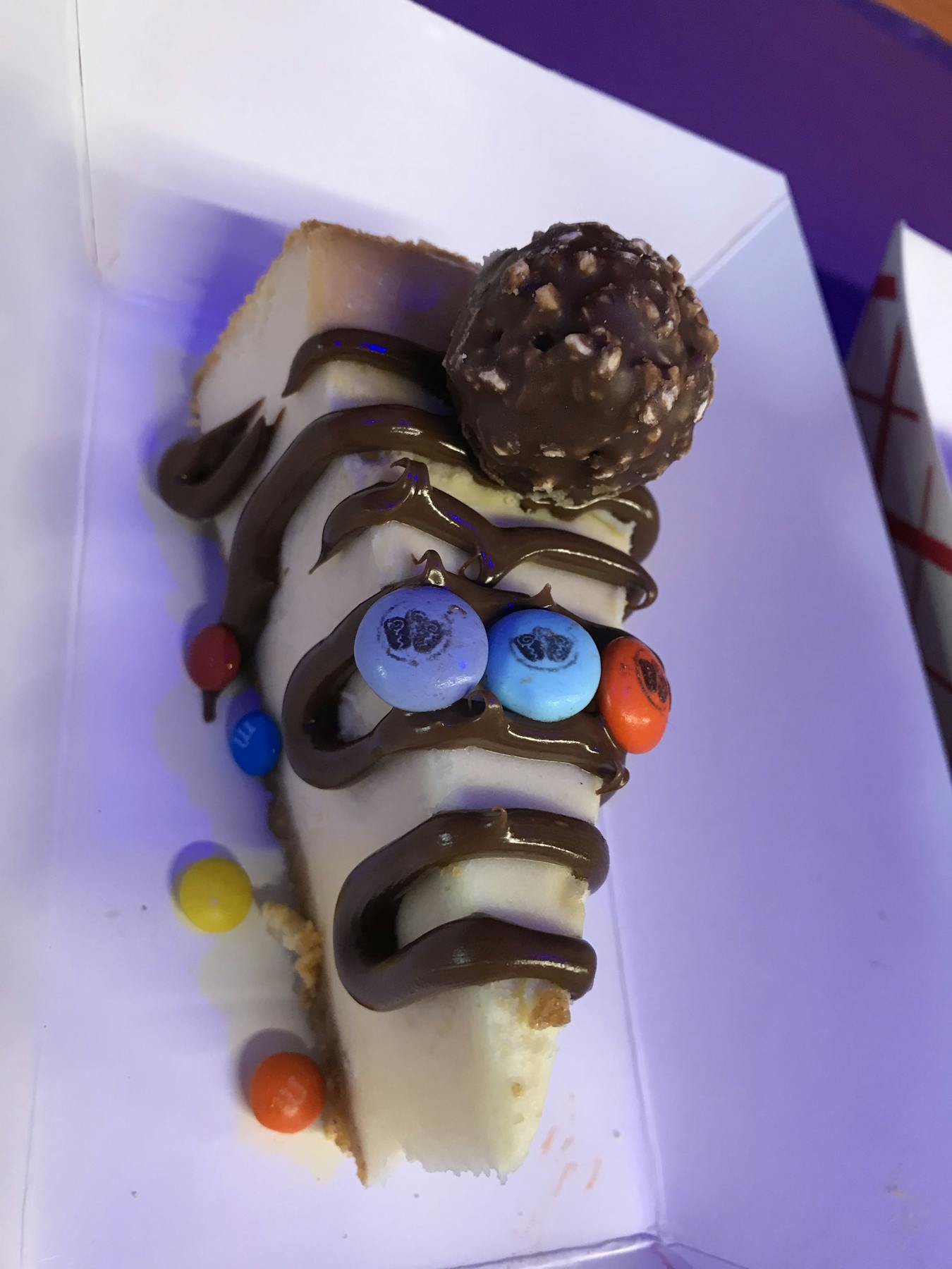 a piece of cake covered in chocolate sitting on top of a table